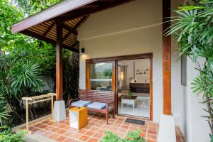 a patio of a house with a bench and a table at Malibu Beach Resort Samui in Chaweng