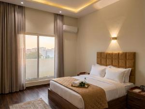 a bedroom with a large bed and a large window at Aura Downtown Suites in Cairo