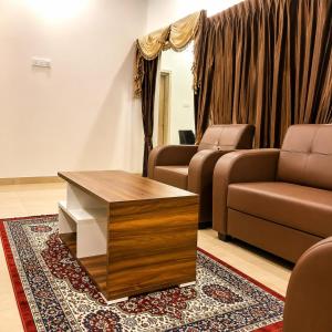 a living room with a couch and a coffee table at Aishwaryam Hotels & service Apartment in Madurai