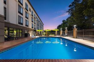 a large blue swimming pool in front of a building at Wingate by Wyndham Little Rock in Little Rock