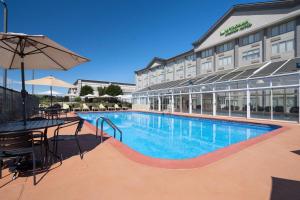 a hotel with a swimming pool in front of a building at Wyndham Garden Manassas in Manassas
