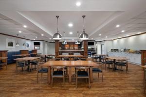 a dining room with wooden tables and chairs at Wyndham Garden Manassas in Manassas