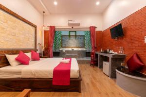 a bedroom with a bed and a tub and a sink at Angkor Rithy Residence 2 in Phumĭ Réach Born (1)