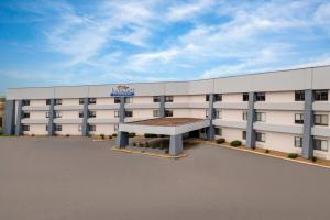 a large white building with a bench in front of it at Baymont by Wyndham Columbia, MO in Columbia