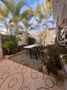 a patio with a table and chairs and palm trees at Casa brisa del caribe in Juan López