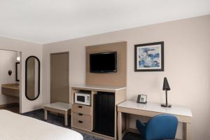 a hotel room with a bed and a desk with a tv at Baymont by Wyndham Columbia, MO in Columbia +37 photos
