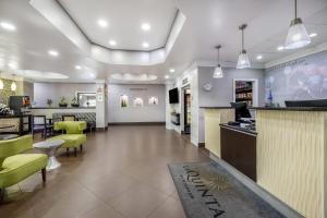 a lobby of a restaurant with green chairs and a bar at La Quinta Inn & Suites by Wyndham Louisville East in Louisville