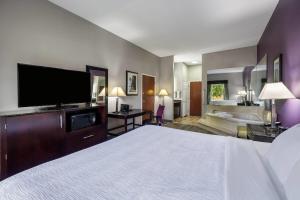 a hotel room with a large bed and a tub at La Quinta Inn & Suites by Wyndham Louisville East in Louisville +65 photos