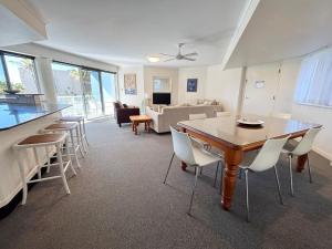 a living room with a dining room table and chairs at Ocean Shores Apartment 13 in South West Rocks