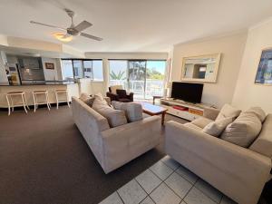 a living room with two couches and a tv at Ocean Shores Apartment 13 in South West Rocks