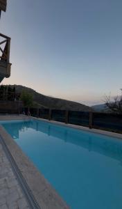 a large blue swimming pool with a fence around it at Zartun Home Dilijan in Gosh