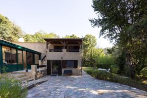 a house with a stone driveway in front of a building at Duplex Très Calme in Meria