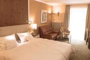a hotel room with a bed and a chair at Aparthotel Alter Weißbräu in Bad Birnbach