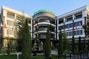 a building with a garden in front of it at Wyndham Garden Tashkent in Tashkent