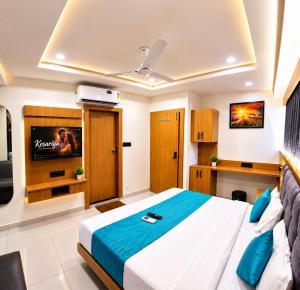 a bedroom with a bed and a flat screen tv at Hotel Sunrise in Ahmedabad