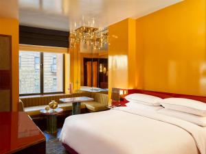 a bedroom with a large bed and a yellow wall at The Manner, The Unbound Collection by Hyatt in New York
