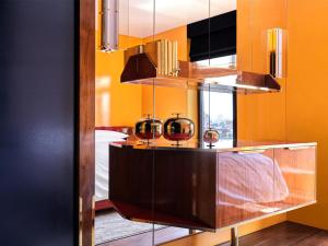 a room with orange walls and a bed and a mirror at The Manner, The Unbound Collection by Hyatt in New York