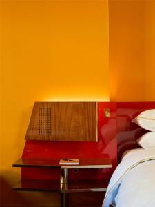 a bed with a red and yellow wall at The Manner, The Unbound Collection by Hyatt in New York