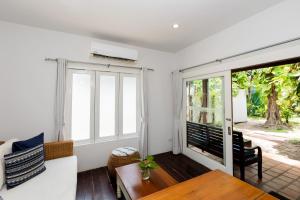a living room with a table and a large window at Malibu Beach Resort Samui in Chaweng