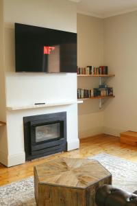 a living room with a fireplace with a tv at The Kyneton Hotel in Kyneton