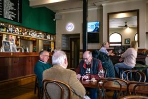 a group of people sitting at a bar at The Kyneton Hotel in Kyneton