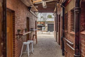 an empty alley with a stool and a brick wall at The Kyneton Hotel in Kyneton