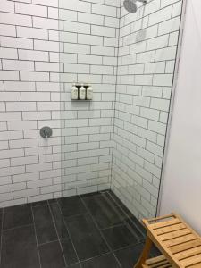 a bathroom with a shower with white tiles at The Kyneton Hotel in Kyneton +37 photos