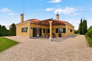 a small yellow house with a roof at Rocha's House - Setúbal in Setubal