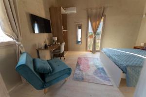 a bedroom with a bed and a chair and a table at U Minnulitu in Caltagirone