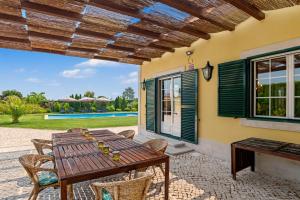 a patio with a wooden table and chairs at Rocha's House - Setúbal in Setubal