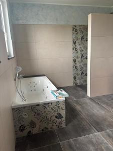 a bathroom with a tub with a book on it at Flachsberg in Huf