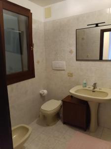 a bathroom with a sink and a toilet and a mirror at Corte Maria in Vicenza