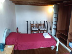 a bedroom with a bed with a red blanket and two chairs at Corte Maria in Vicenza