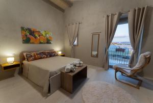 a bedroom with a bed and a large window at U Minnulitu in Caltagirone
