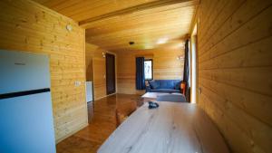 a wooden room with a wooden table and a couch at SkyGona Alpine Retreat in Ghebi