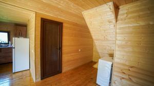 a wooden room with a door and a refrigerator at SkyGona Alpine Retreat in Ghebi