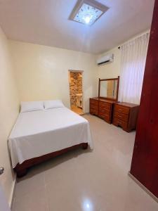 a bedroom with a bed and a dresser and a mirror at Casa brisa del caribe in Juan López