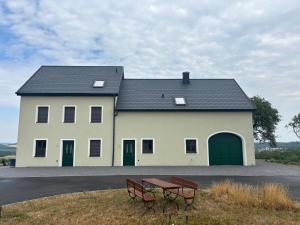 a large white house with a picnic table in front of it at Flachsberg in Huf