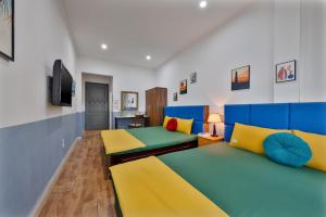 a large room with two beds and a tv at Hanoi Sihouse Eco in Hanoi