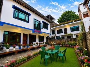 a patio with a table and chairs in front of a building at Derban guest house in Srinagar