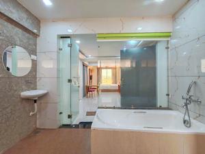 a bathroom with a tub and a sink and a mirror at Lions Hotel Adidev in Badlapur +42 photos