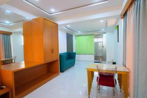 a room with a table and chairs and a green wall at Lions Hotel Adidev in Badlapur