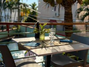 a table with a wine glass on a balcony at Résidence Padma in Flic-en-Flac