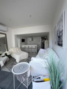 a living room with a couch and a table at Little White House in Anglet +3 photos