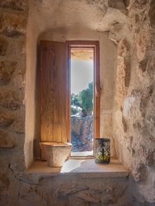 a window in a stone building with a vase on a window sill at Can Rata in Tivenys