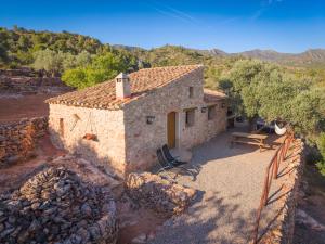 a small stone house with a table and a fence at Can Rata in Tivenys