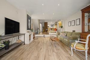 a living room with a couch and a flat screen tv at Casa Del Sol in Calafell