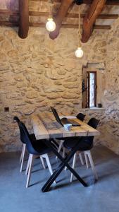 a wooden table and chairs in a room with a stone wall at Can Rata in Tivenys +16 photos