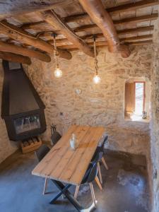 a wooden table in a room with a stove at Can Rata in Tivenys