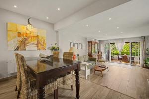 a dining room with a table and a living room at Casa Del Sol in Calafell